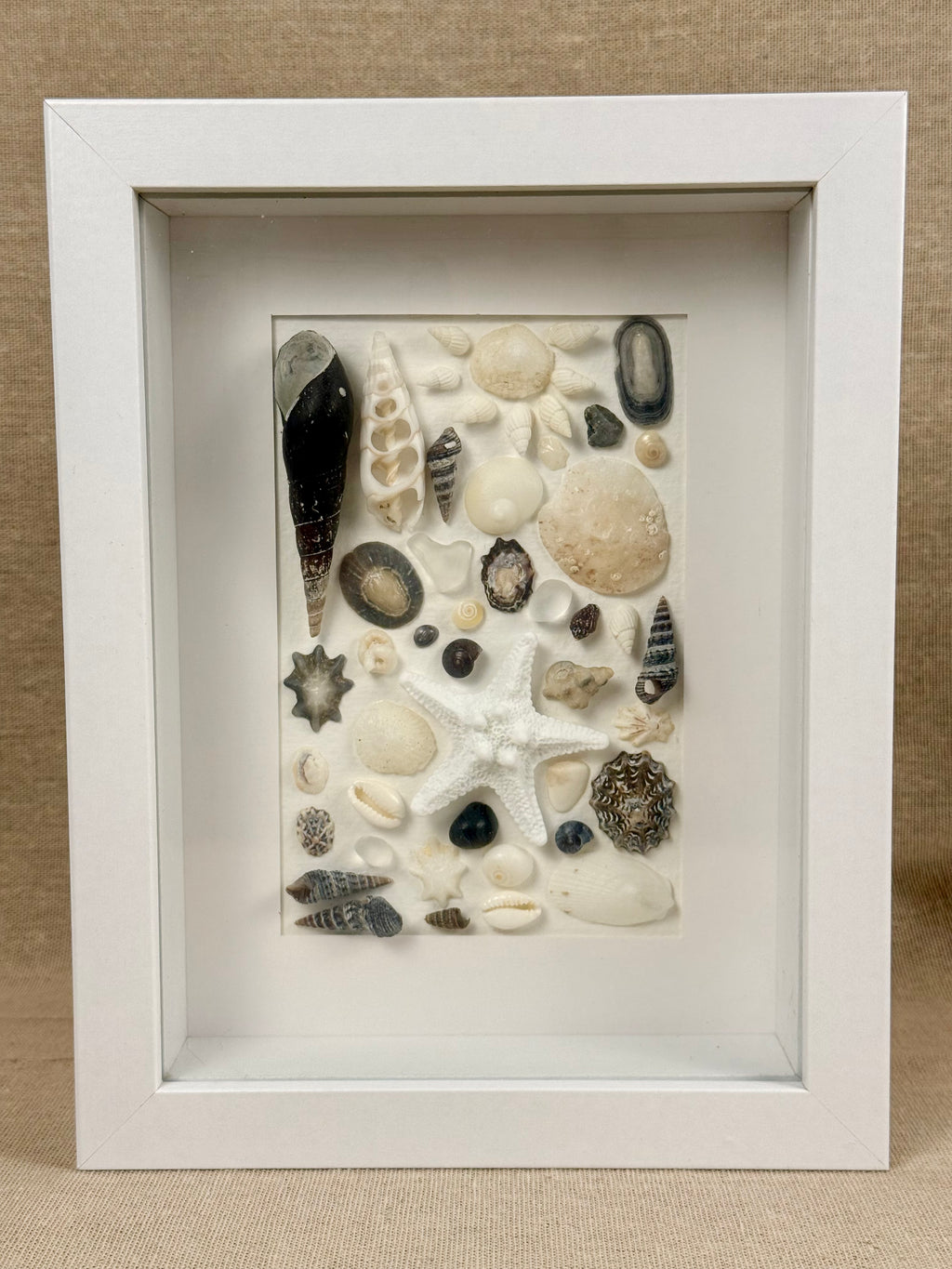 Shell Art – Coastal Collection

Bring a touch of the Australian coast into your home with this delicate handmade shell art.

A beautiful selection of natural seashells, sea glass and a small starfish are carefully arranged in soft shades of white, ivory a